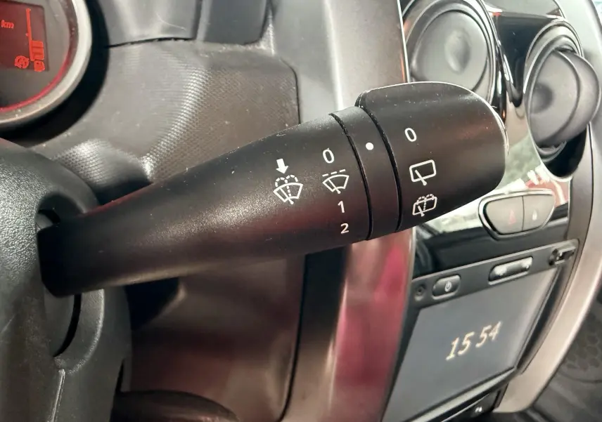 Gros plan sur la commande d’essuie-glace à gauche du volant dans l’habitacle du Dacia Duster noir métal 2017.