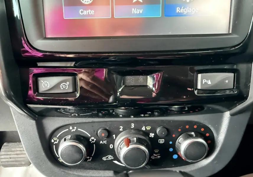 Gros plan sur la console centrale du Dacia Duster noir métal 2017, montrant les commandes de climatisation et l'écran tactile.