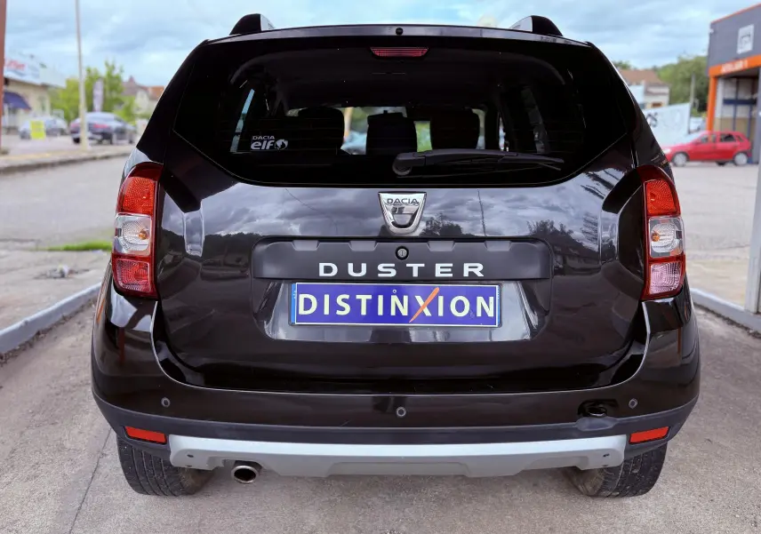 Vue arrière d'un Dacia Duster noir métal 2017 avec logo Dacia et plaque d'immatriculation personnalisée "DISTINXION".