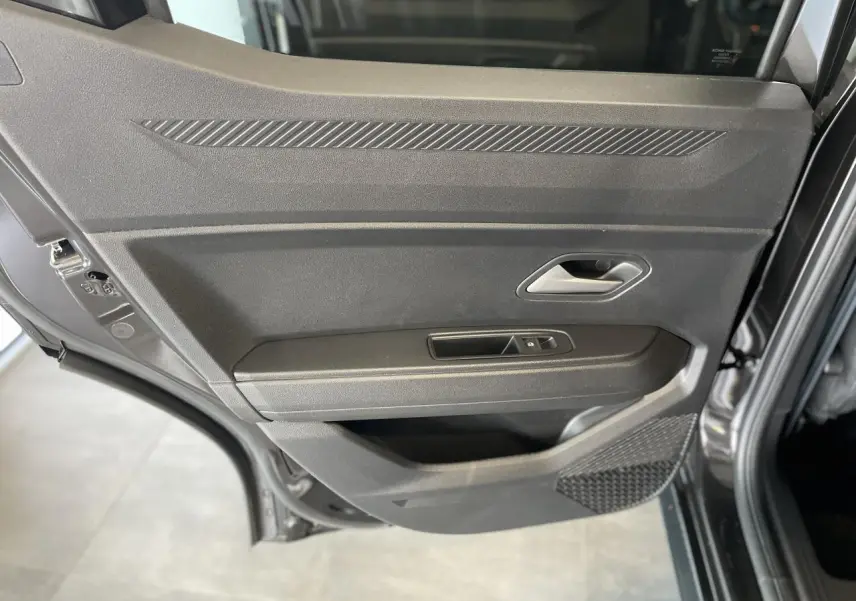 Porte arrière côté gauche noire métallisée du Dacia Duster 2025 avec poignée argentée et commande de vitre électrique.
