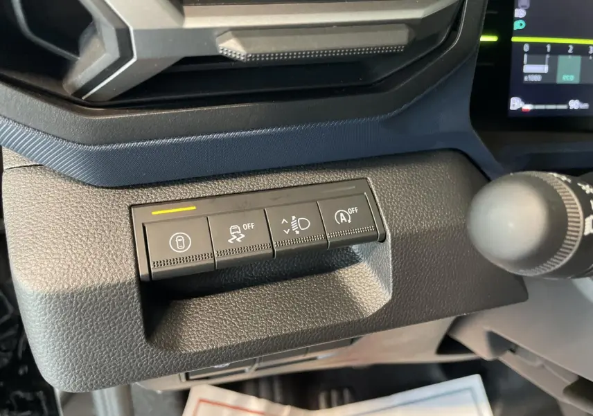 Gros plan sur les commandes de sécurité du tableau de bord du Dacia Duster noir métallisé 2025, côté gauche.