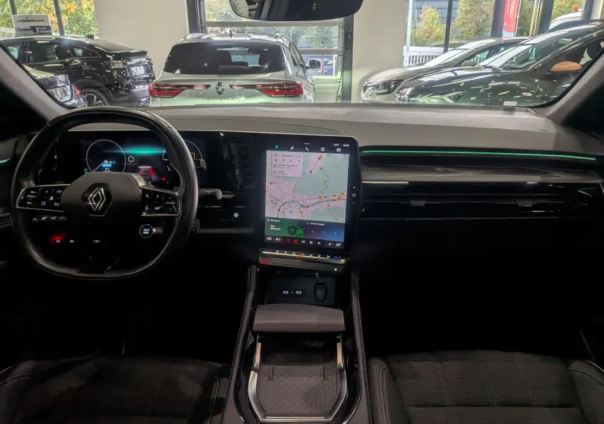 Intérieur du Renault Austral E-TECH 2024, vue frontale sur le tableau de bord noir avec écran tactile central et volant multifonction.