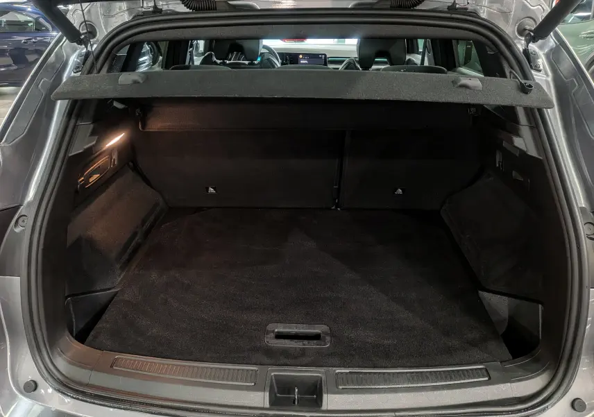Coffre ouvert du Renault Austral E-TECH gris schiste, vue arrière montrant l'espace de chargement et la tablette cache-bagages.