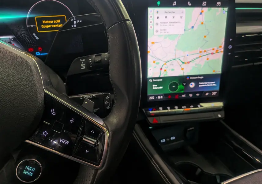 Intérieur du Renault Austral E-TECH 2024, vue sur le volant noir et l'écran tactile central affichant la navigation.