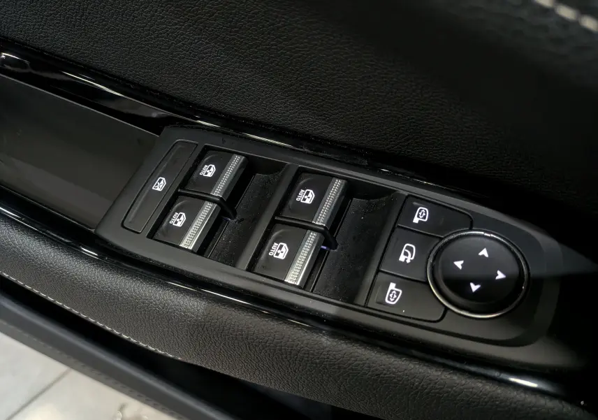 Gros plan sur les commandes des vitres électriques et rétroviseurs côté conducteur du Renault Austral gris Schiste 2024.