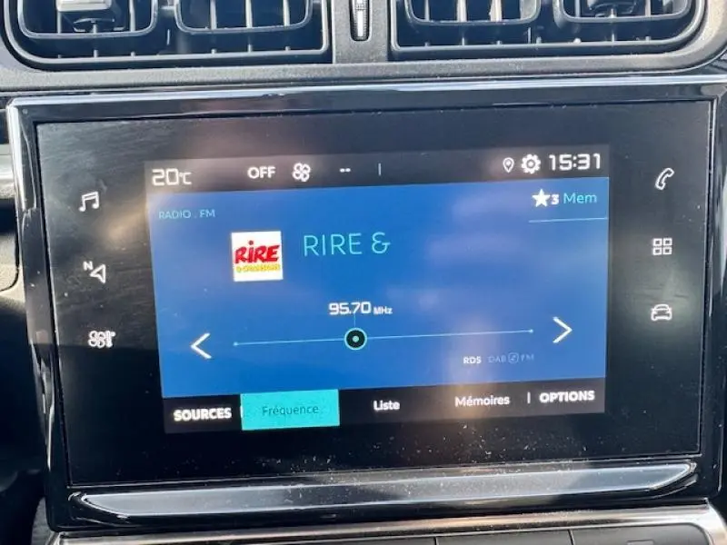 Écran tactile central de la Citroën C3 2021 affichant la radio FM sur la fréquence 95,7 MHz, ambiance intérieure noire.