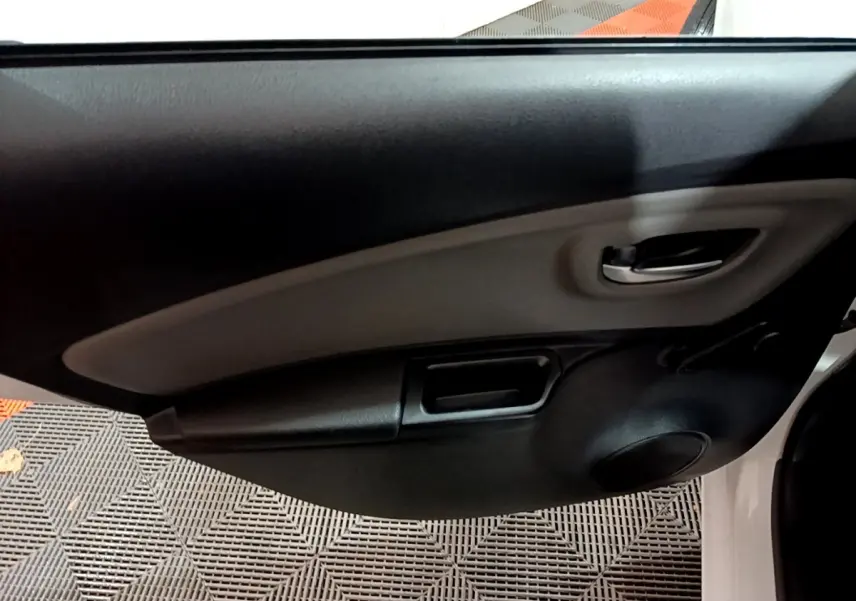 Détail de la porte avant gauche intérieure noire et grise d’une Toyota Yaris blanche hybride 2019.