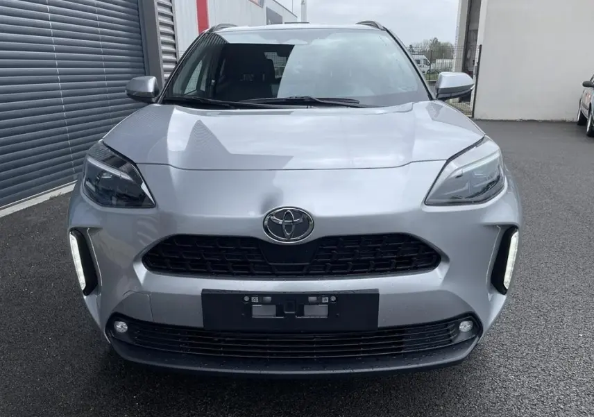 Vue avant d'une Toyota Yaris Cross 1.5 Hybrid 130h Design gris clair avec feux LED et calandre noire.
