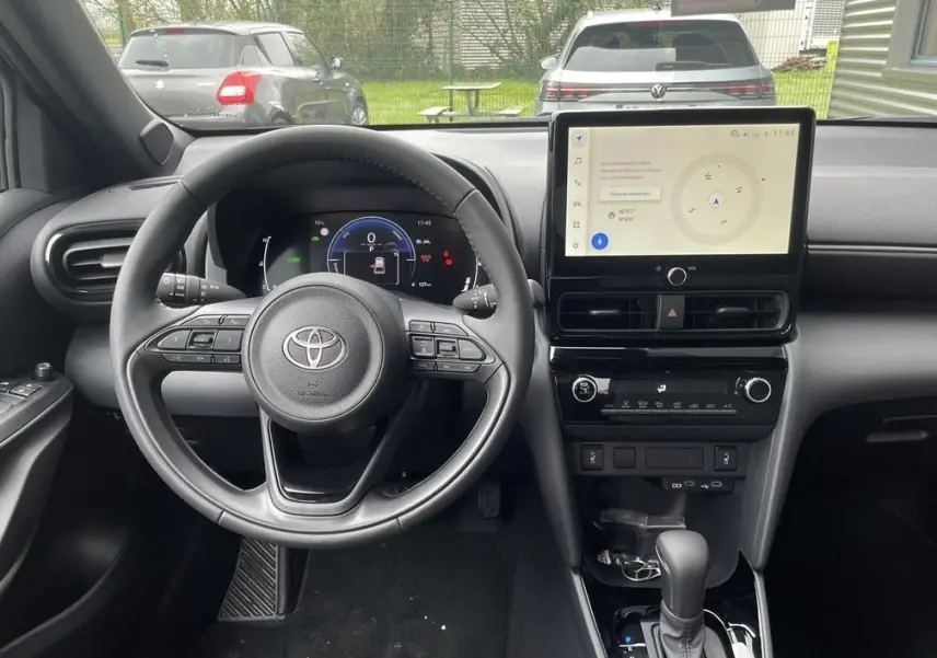 Vue intérieure frontale du tableau de bord noir et volant cuir de la Toyota Yaris Cross 1.5 Hybrid 130h Design Auto.