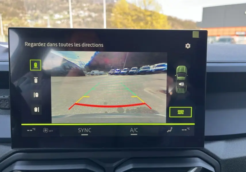 Écran central montrant la caméra multiview du Dacia Bigster Hybrid 155 Expression Plus avec vue arrière sur un parking.