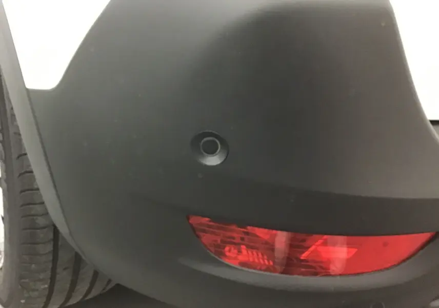 Gros plan sur le feu arrière droit rouge et le pare-chocs noir du Peugeot 5008 blanc nacré 2024.