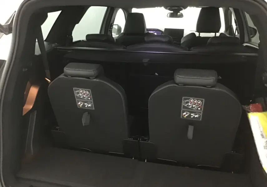 Vue arrière intérieure du Peugeot 5008 blanc nacré 2024, montrant les sièges rabattus de la troisième rangée.
