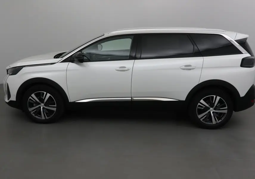 Profil latéral droit du Peugeot 5008 blanc nacré 2024 avec jantes alliage et vitres teintées.