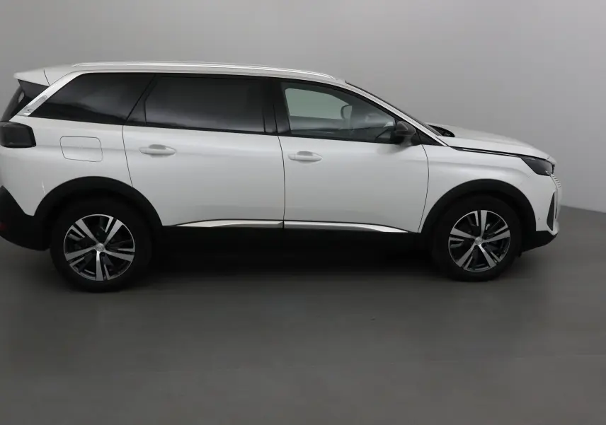 Peugeot 5008 blanc nacré vue de profil côté gauche, SUV hybride 7 places avec jantes alliage et vitres teintées.