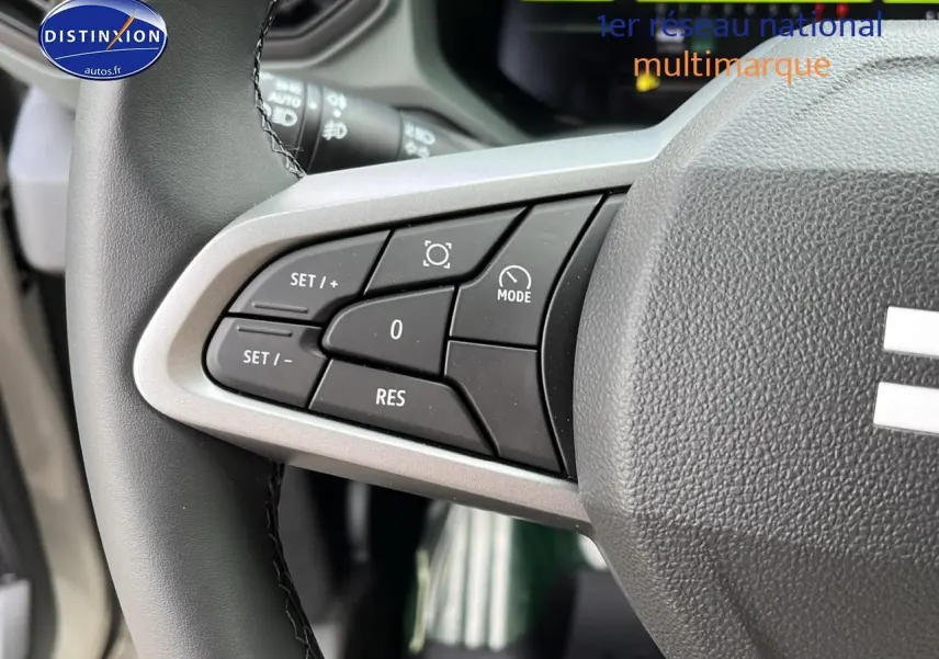 Gros plan sur les commandes du régulateur de vitesse au volant du Dacia Duster 2025 couleur Sandstone.