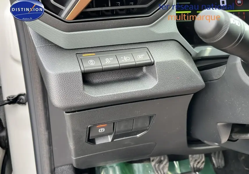 Détail du tableau de bord côté gauche du Dacia Duster Sandstone 2025 avec commandes d'assistance et frein électrique.