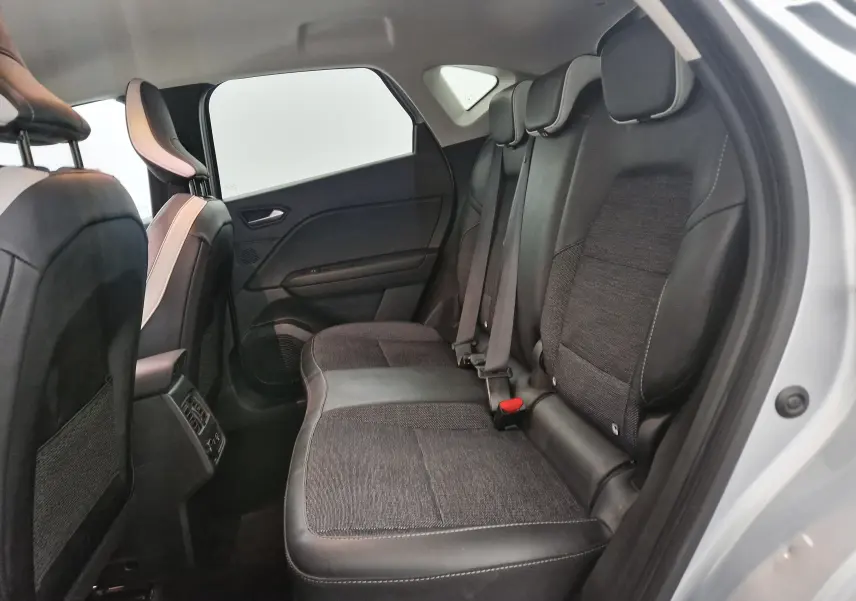 Vue intérieure côté droit sur la banquette arrière en tissu et cuir du Renault Captur 2024 gris Highland/noir.