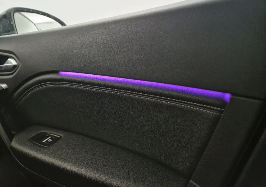 Gros plan sur la garniture de la porte côté gauche du Renault Captur 2024 avec éclairage d'ambiance violet intégré.