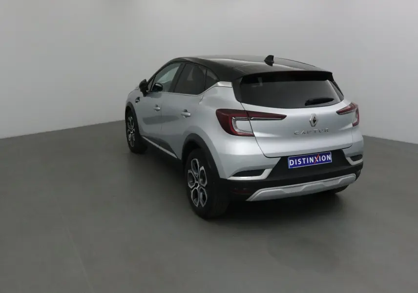 Vue 3/4 arrière droite d'un Renault Captur 2024 gris Highland avec toit noir et jantes alliage.