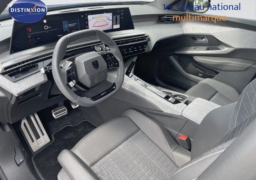 Intérieur du Peugeot 5008 Hybrid 2025 vu côté conducteur, avec volant compact et sellerie cuir gris clair.