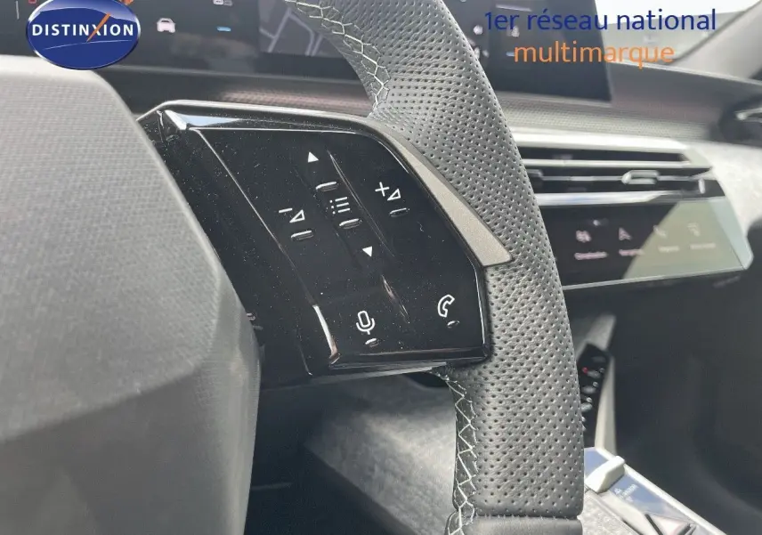 Gros plan sur la partie gauche du volant en cuir perforé noir avec commandes tactiles du Peugeot 5008 Hybrid 2025.