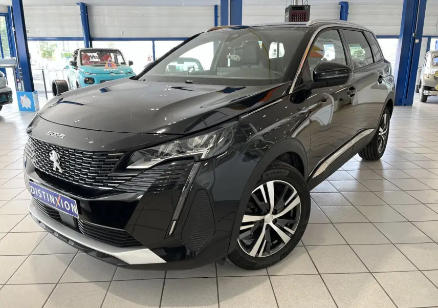 Peugeot 5008 noir métallisé vue 3/4 avant droit en intérieur avec jantes alliage bi-ton et calandre chromée.