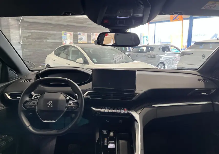 Intérieur noir du Peugeot 5008 2024 vu de face, avec tableau de bord moderne et écran tactile central.