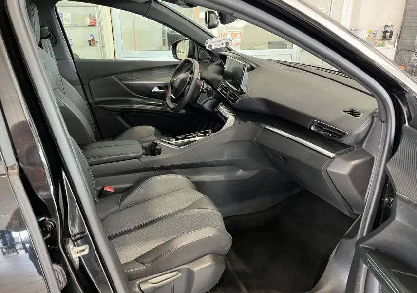 Intérieur avant droit du Peugeot 5008 noir métallisé, tableau de bord moderne avec écran tactile et sellerie TEP & tissu.