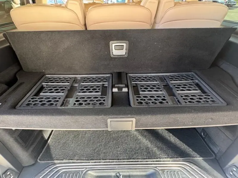 Coffre ouvert du Mercedes Classe V 250 d Long Avantgarde montrant le plancher de rangement noir et les sièges arrière beige.