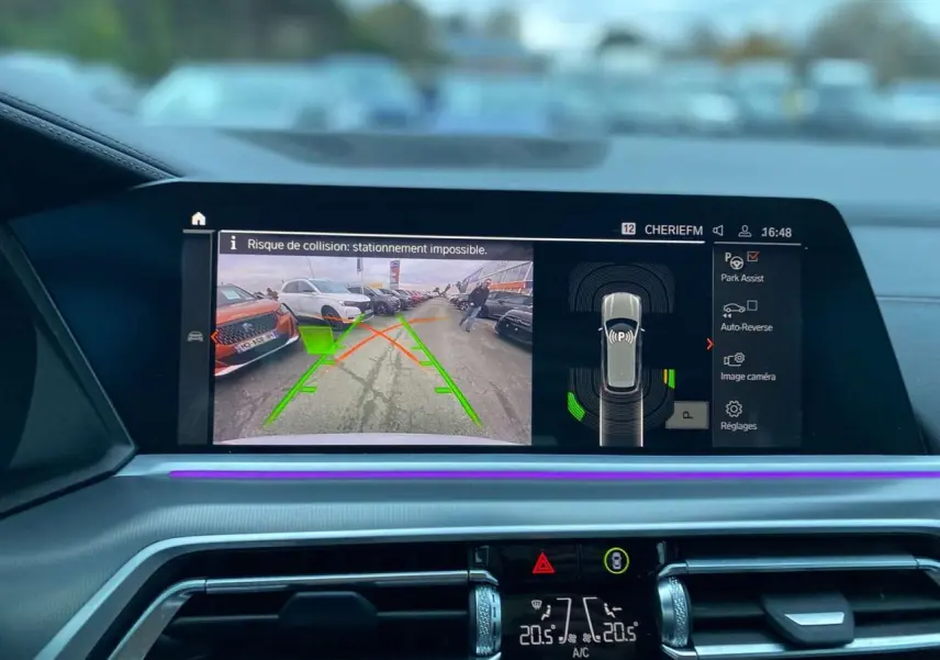 Affichage de l'écran intérieur du BMW X5 blanc 2022 montrant la caméra de recul et l'assistance au stationnement.