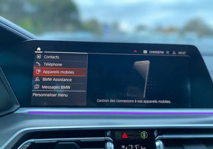 Écran central du tableau de bord du BMW X5 blanc 2022, affichant le menu de gestion des appareils mobiles.