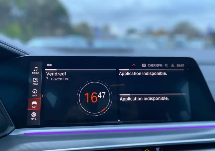 Écran central du tableau de bord du BMW X5 blanc 2022 affichant l'heure et un message d'application indisponible.