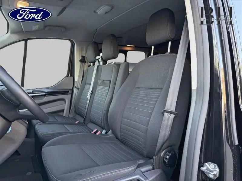 Vue intérieure côté droit du Ford Transit Custom Fourgon 2023, sièges noirs avec ceintures grises visibles.