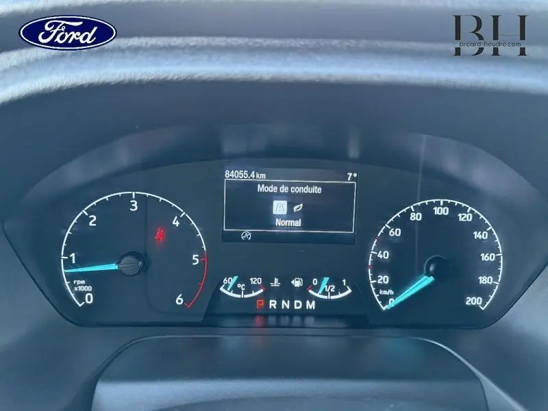 Vue rapprochée du tableau de bord numérique du Ford Transit Custom noir, affichant le mode de conduite normal et le compteur kilométrique.