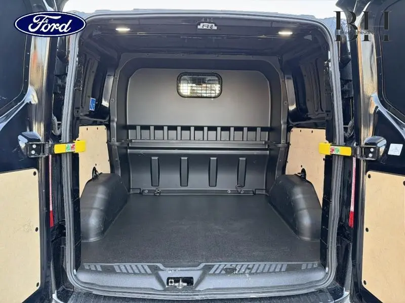Vue arrière ouverte du fourgon Ford Transit Custom noir Agate métallisée, montrant l'espace de chargement vide et protégé.