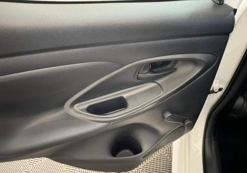 Vue intérieure du panneau de porte avant gauche noir d'une Toyota Yaris blanche hybride 2022.