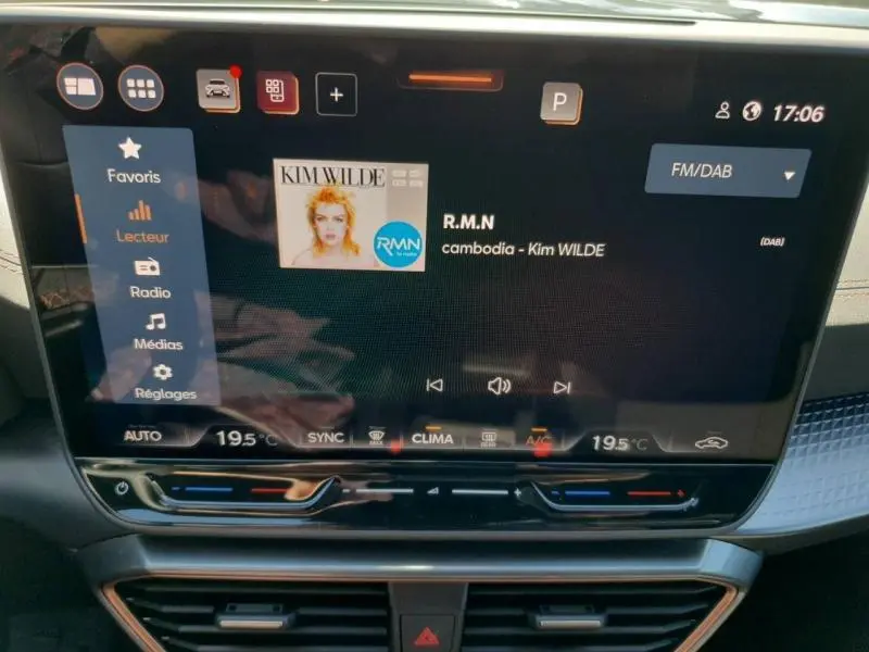 Vue rapprochée de l’écran tactile central du tableau de bord du CUPRA Formentor bleu, affichant la radio FM/DAB.