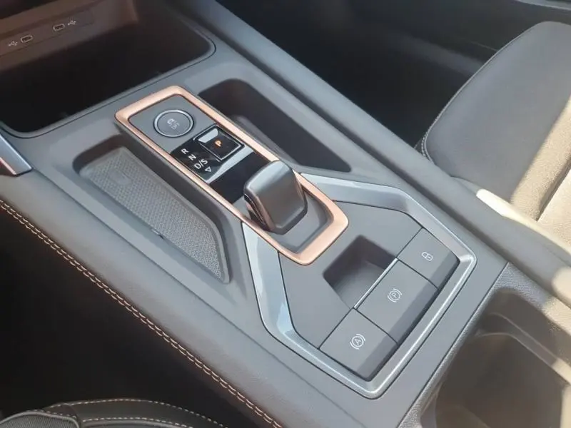 Vue rapprochée de la console centrale du CUPRA Formentor 1.5 eTSI Hybrid avec levier de vitesse électronique et finitions cuivre.