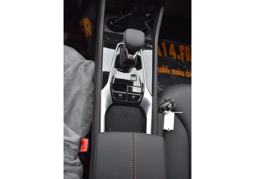 Vue plongeante sur la console centrale noire du MG Motor EHS avec levier de vitesse et clé posée sur le siège passager.