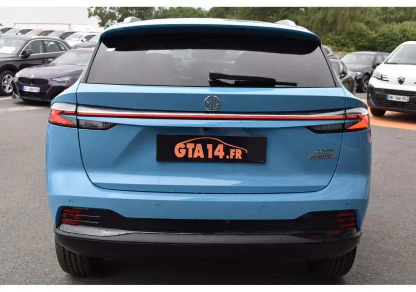 Vue arrière d'un MG MOTOR EHS bleu avec feux LED reliés par une bande lumineuse rouge et logo central.