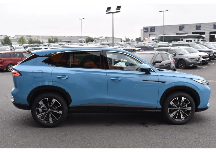 Vue de profil côté gauche du SUV MG EHS 1.5 Hybrid+ bleu avec jantes alliage 19 pouces et vitres surteintées.