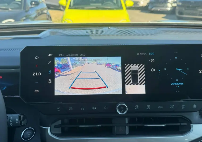 Vue intérieure du tableau de bord du Jeep Compass 2026 avec écran tactile affichant la caméra de recul et les commandes climatiques.