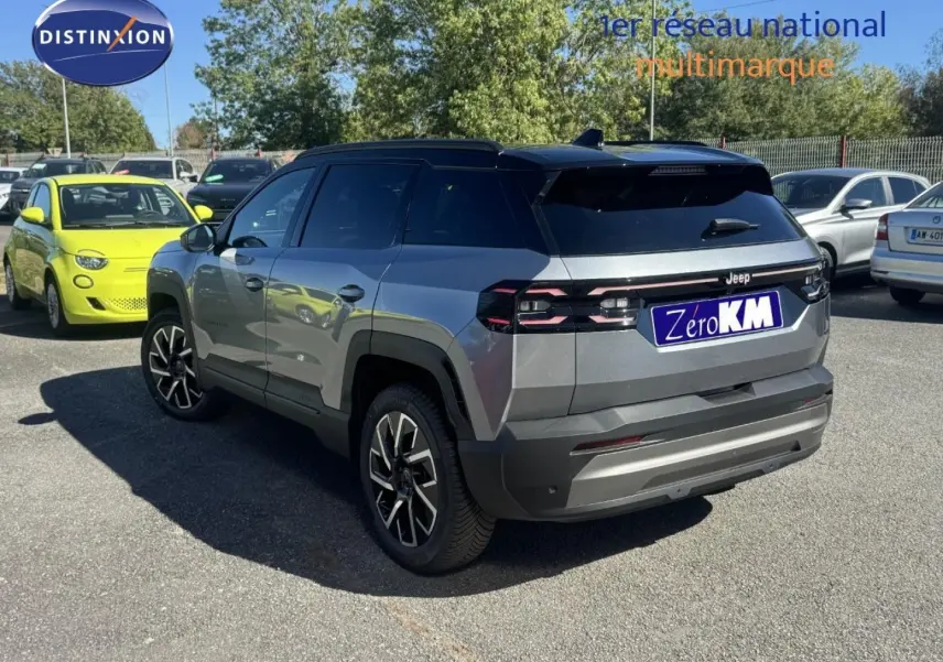 Vue 3/4 arrière droite d'un Jeep Compass Yosemite gris avec toit noir, jantes alu et feux arrière LED distinctifs.