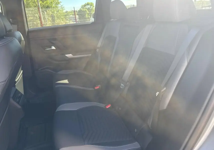 Vue intérieure côté droit sur la banquette arrière en tissu gris et noir du Jeep Compass 2026 avec ceinture de sécurité visible.