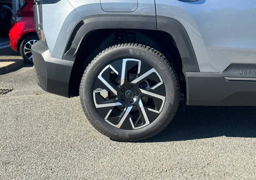 Gros plan sur la roue arrière droite du Jeep Compass Yosemite gris avec jante alu noire et grise, détails du pneu Michelin visibles.