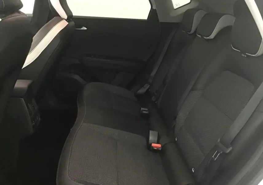 Vue intérieure des sièges arrière noirs du Renault Captur 2024, avec appuie-têtes et ceintures visibles côté droit.