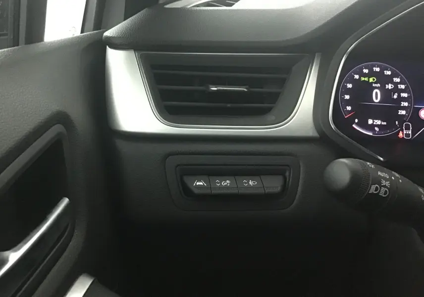 Détail du tableau de bord côté gauche du Renault Captur 2024 blanc nacré, avec commandes d'assistance et ventilation.