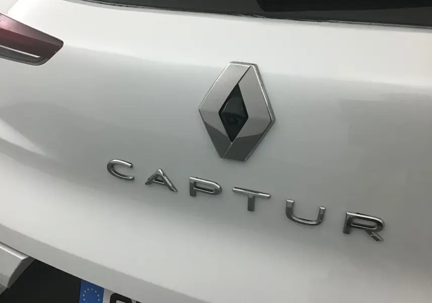 Gros plan sur l'arrière blanc nacré du Renault Captur 2024 avec logo et caméra de recul intégrée.