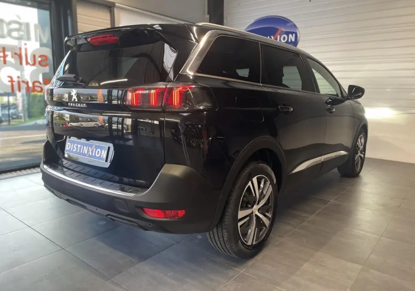 Peugeot 5008 noir métallisé vue 3/4 arrière droit avec feux arrière LED 3D et jantes alliage bi-ton.