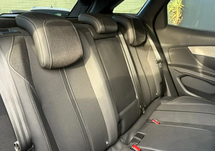 Vue intérieure des sièges arrière noirs en Mi-TEP/tissu du Peugeot 3008 2023, avec ceintures et appuie-têtes visibles.